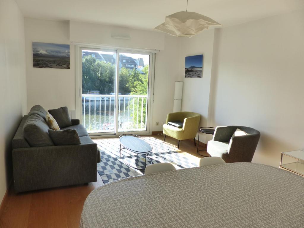 un salon avec un canapé, des chaises et une table dans l'établissement La Fontaine,T2 au calme , parking, vue Erdre, à Nantes