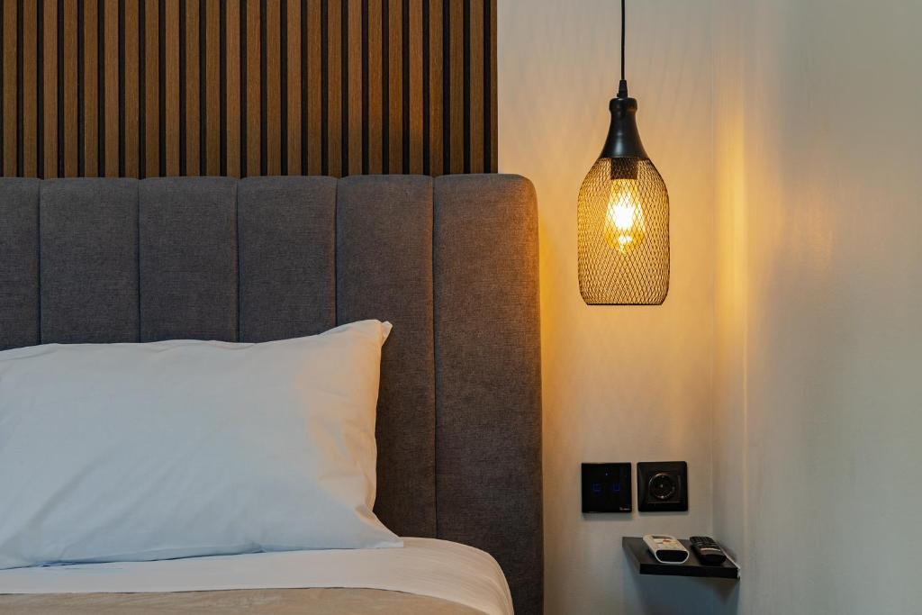 a bedroom with a bed and a pendant light at Noir Residence - Chic 2Br House Near Maleme Beach in Maleme