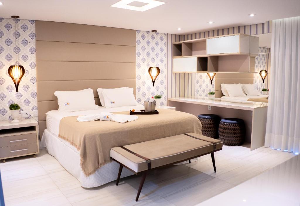 sypialnia z dużym łóżkiem i białymi poduszkami w obiekcie Golf Ville Resort Brisa do Golf -Apartamentos e Cobertura w mieście Aquiraz