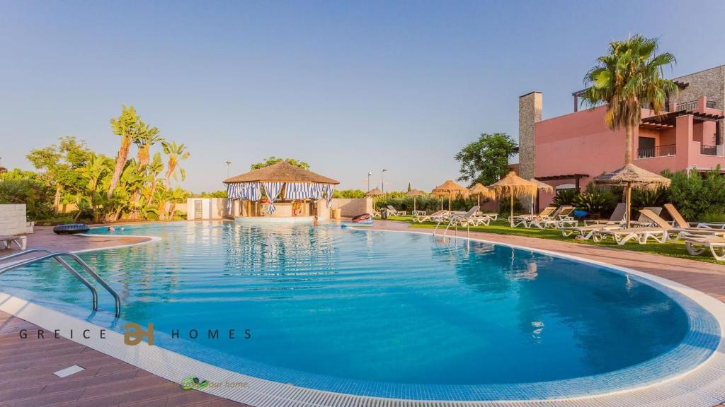 una piscina in un resort con sedie e gazebo di Greice Homes-Luxury 2 bed en-suite south facing & Golf view a Quarteira