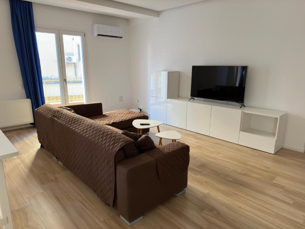 a living room with a couch and a flat screen tv at Fabio's Place in Castelvetrano Selinunte
