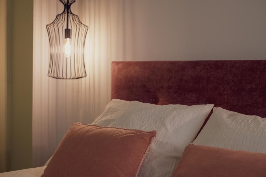 a bedroom with a bed with a brown headboard and a light at Apartamento Urbano Granada in Granada