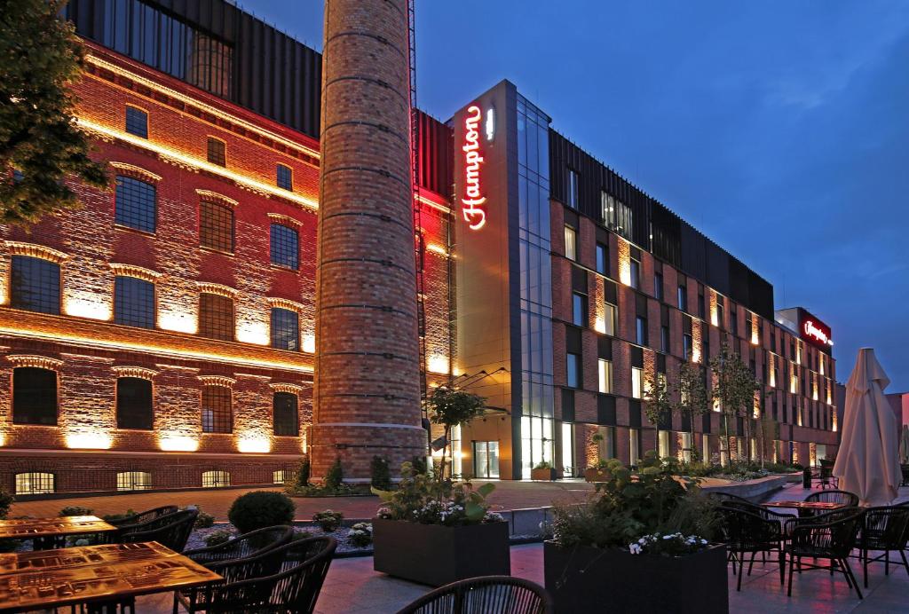 卡利什Hampton By Hilton Kalisz的一座带烟 ⁇ 和桌椅的建筑