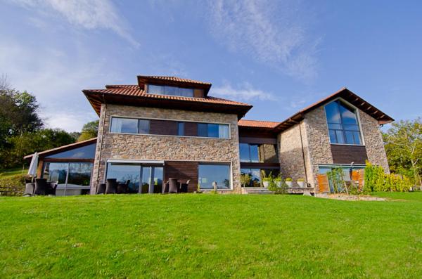 a large house with a green lawn in front of it at La Casona de Abamia in Corao