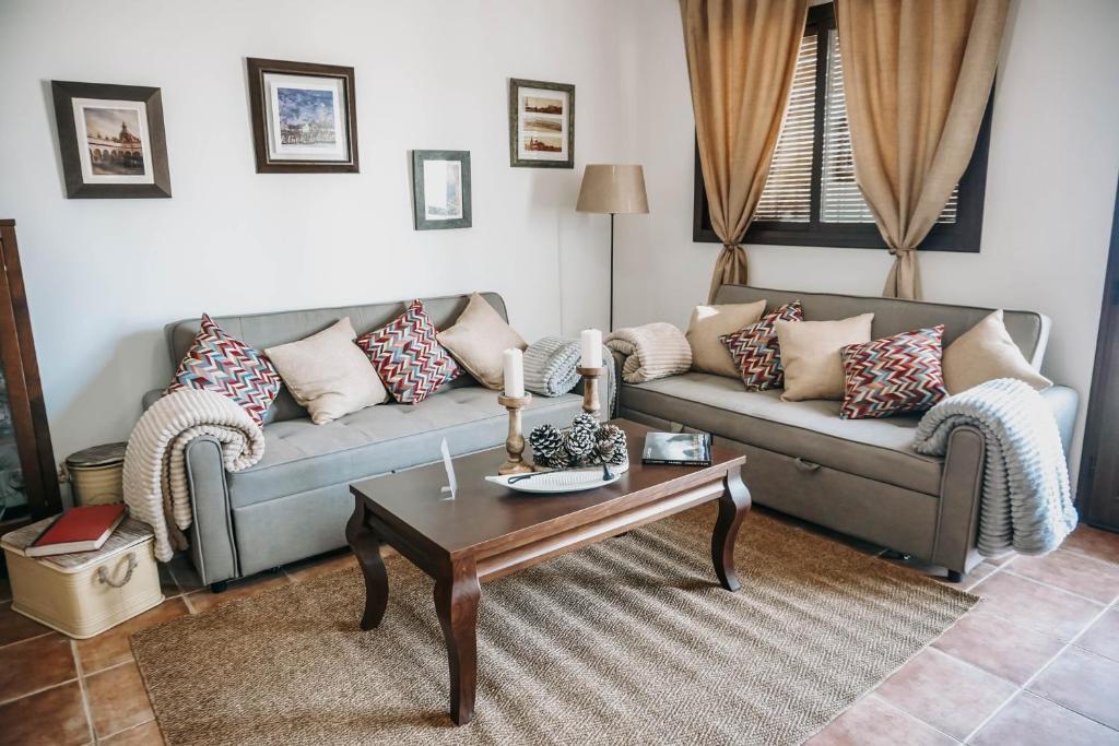 ein Wohnzimmer mit einer Couch und einem Couchtisch in der Unterkunft Fantástica casa con piscina Carmona Sevilla in Brenes