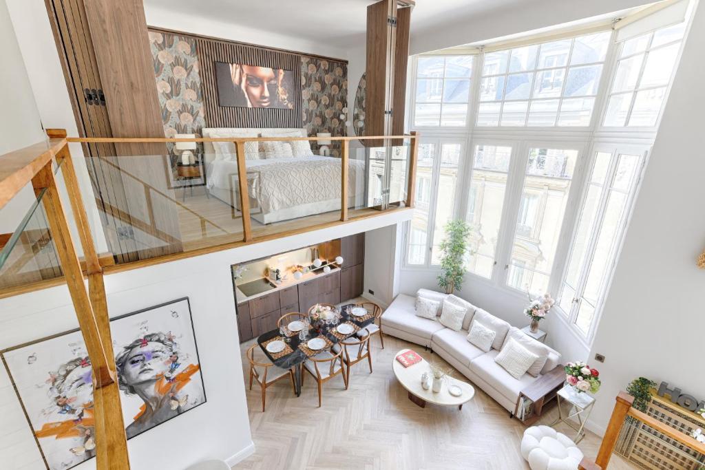un salon avec un lit mezzanine et un canapé dans l'établissement Duplex à deux pas des Champs Elysée, à Paris
