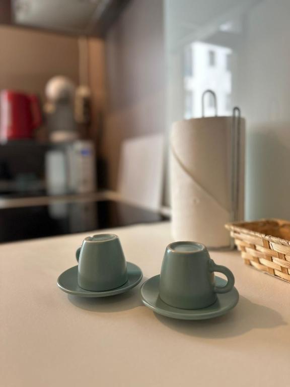 two green cups sitting on top of a counter at D&E Apart in Bucharest