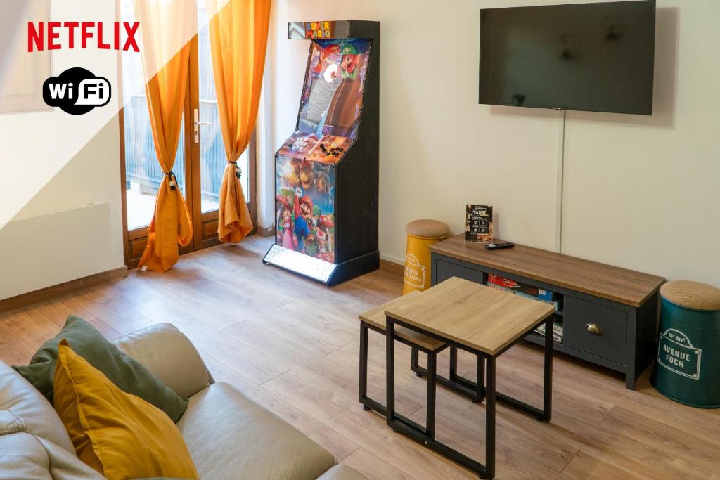 un salon avec une télévision et une table dans l'établissement 'Maison Lison' le Calme en ville, à Annoeullin