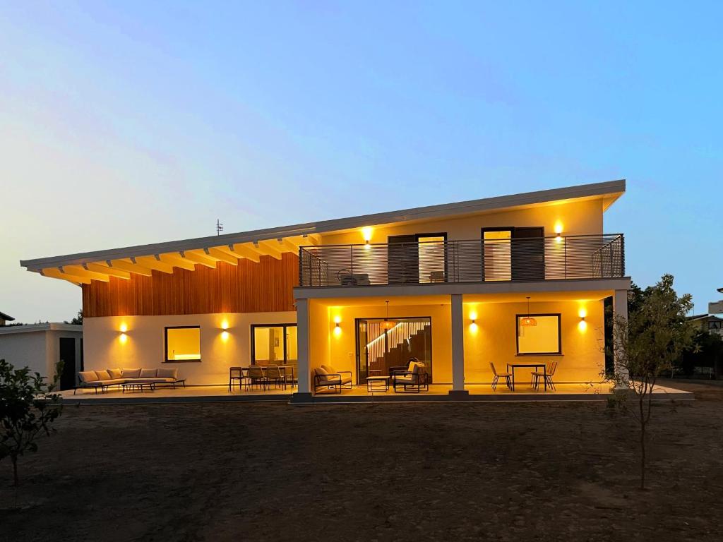 a large house with tables and chairs in front of it at Amarina - appartamento boutique sul mare in Marina di Davoli