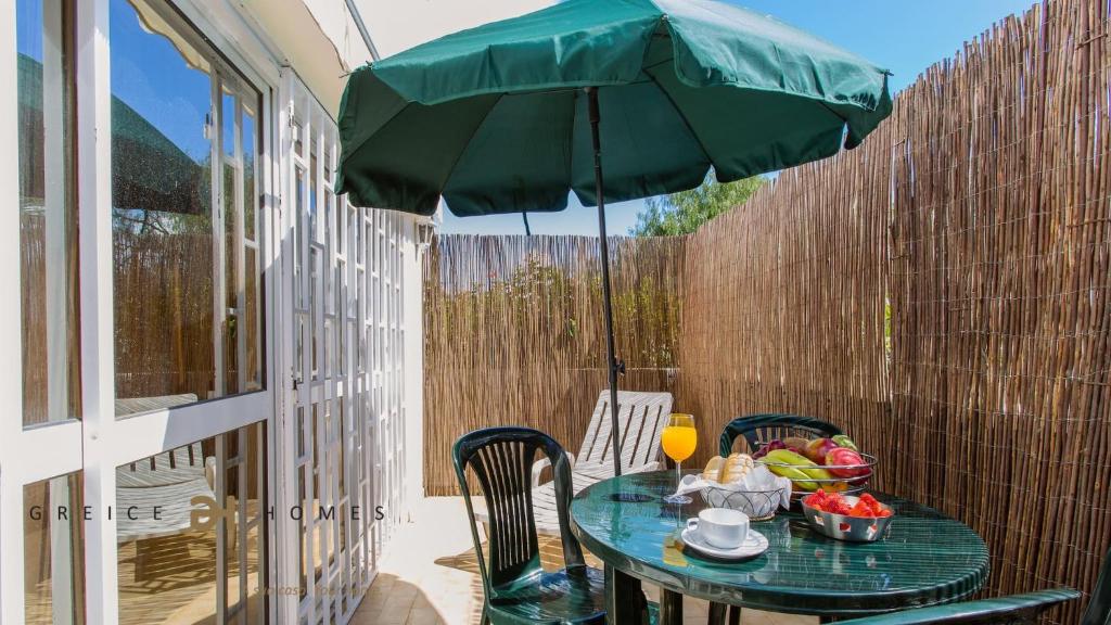 a table with a green umbrella on a patio at GREICE HOMES 1 BEDROOM APARTMENT CENTRE OF VILAMOURA in Vilamoura
