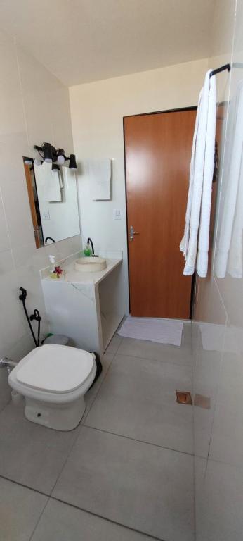a bathroom with a toilet and a sink and a shower at Loft espaçoso e confortável in Três Marias
