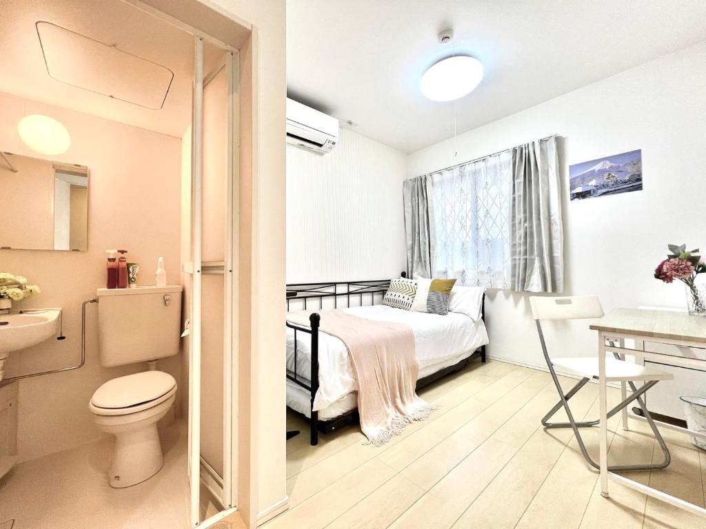 a small bedroom with a bed and a bathroom at Nerima house in Tokyo