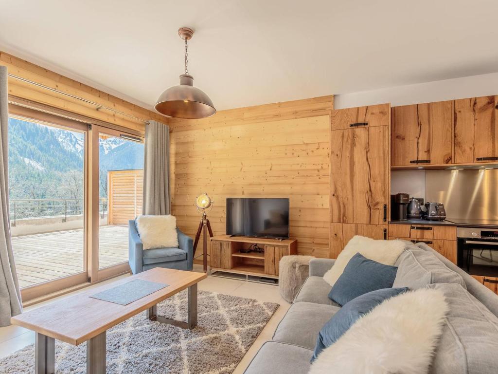 un salon avec un canapé et une télévision dans l'établissement Appartement 4* 4 chambres pour 8/10 pers, terrasse, parking, proche piscine et spa - FR-1-638-20, à Champagny-en-Vanoise