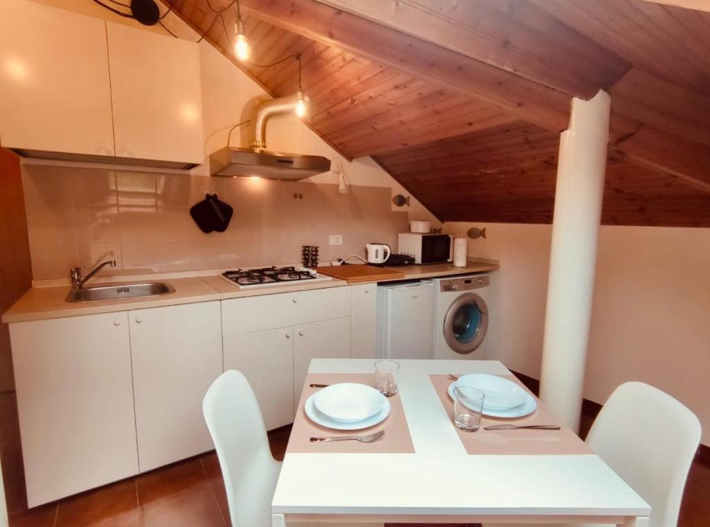 een keuken met een witte tafel en witte stoelen bij CASTAGNETO 8 in Rapallo