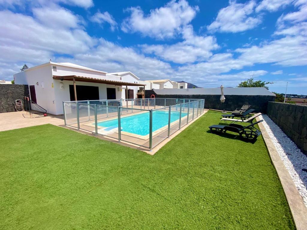 a house with a swimming pool in a yard at Villa Abuelo Paco - Private heated pool in Playa Blanca