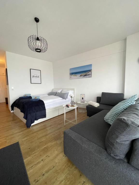 a living room with a bed and a couch at Skyline Suite Augsburg-Stilvoll & zentral in Augsburg