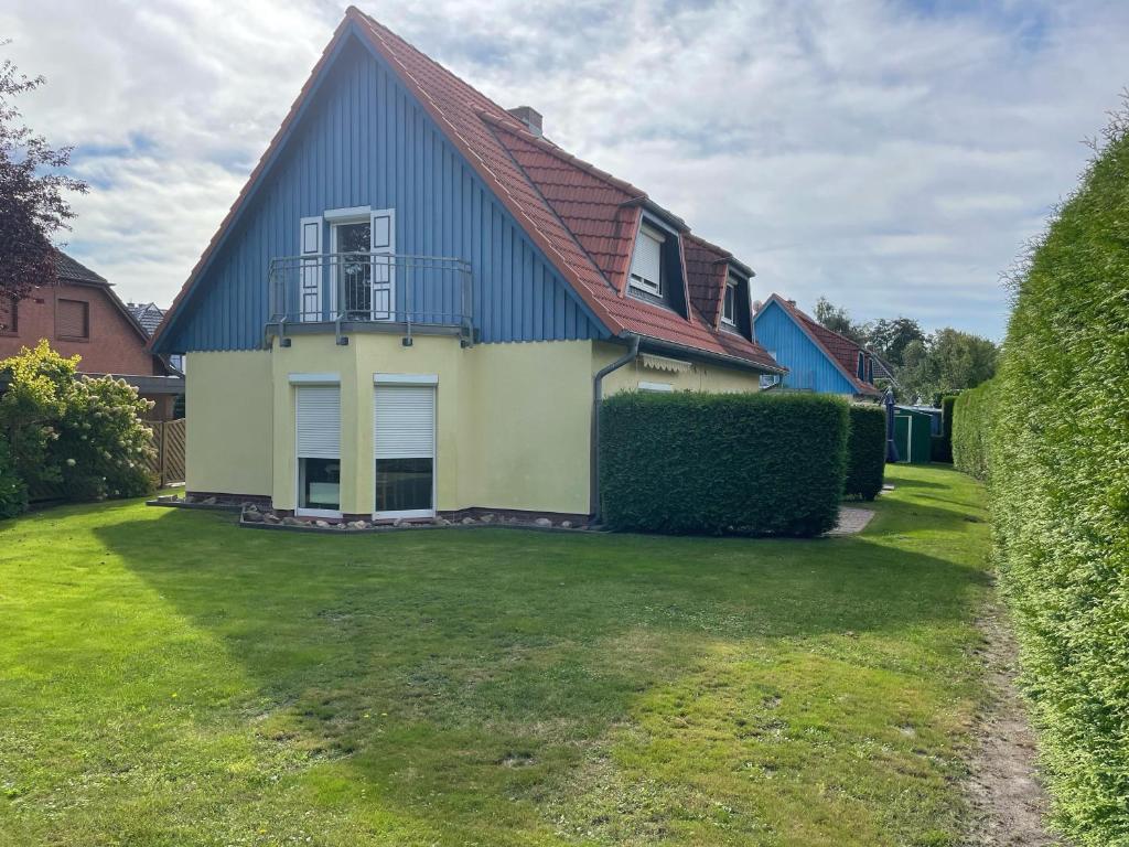 a house with a red roof and a green yard at Lee in Zingst