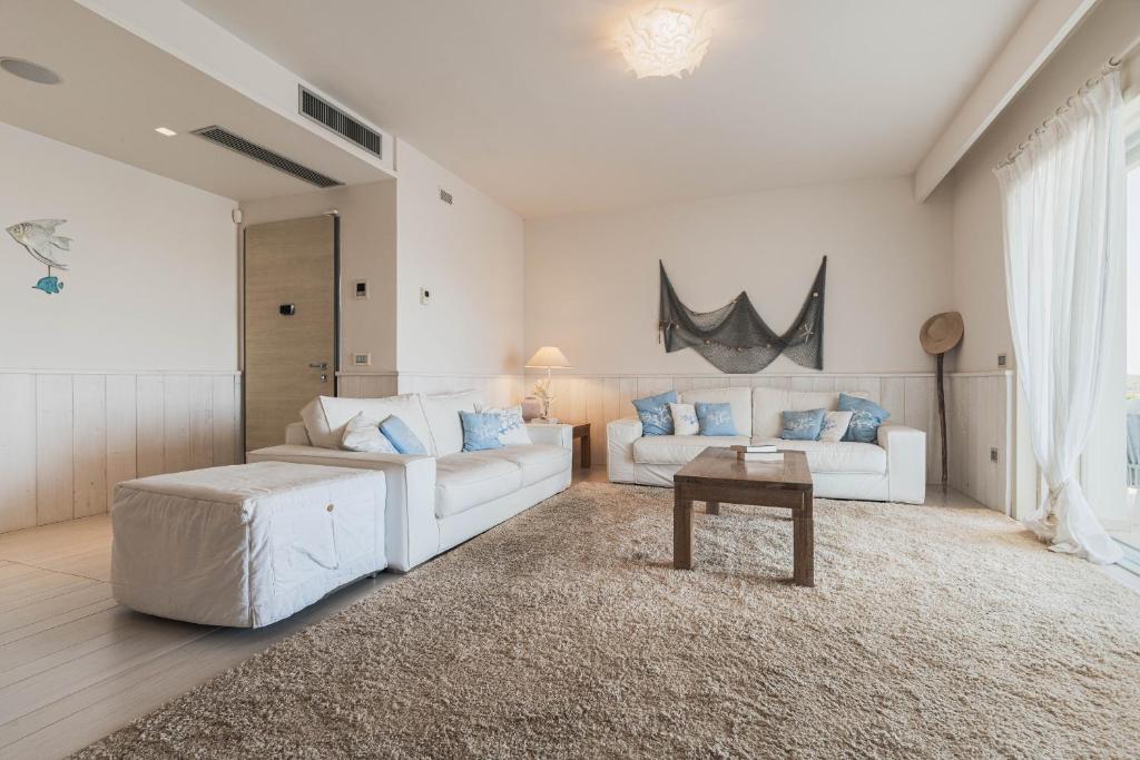 - un salon avec deux canapés blancs et une table dans l'établissement Villa Blue Sphere with Pool by Wonderful Italy, à Olbia 34 autres photos