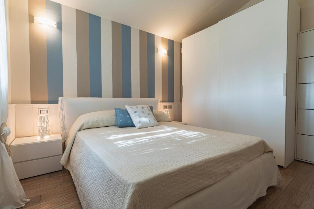 - une chambre avec un lit et un mur rayé dans l'établissement Villa Blue Sphere with Pool by Wonderful Italy, à Olbia