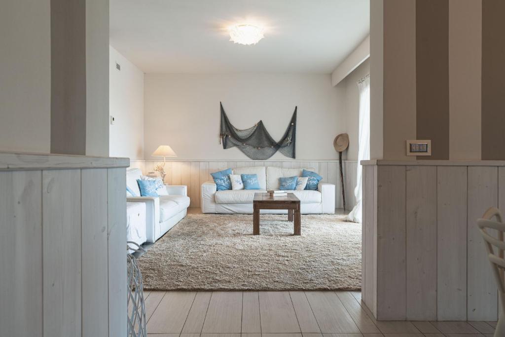 un salon avec un canapé blanc et une table dans l'établissement Villa Blue Sphere with Pool by Wonderful Italy, à Olbia