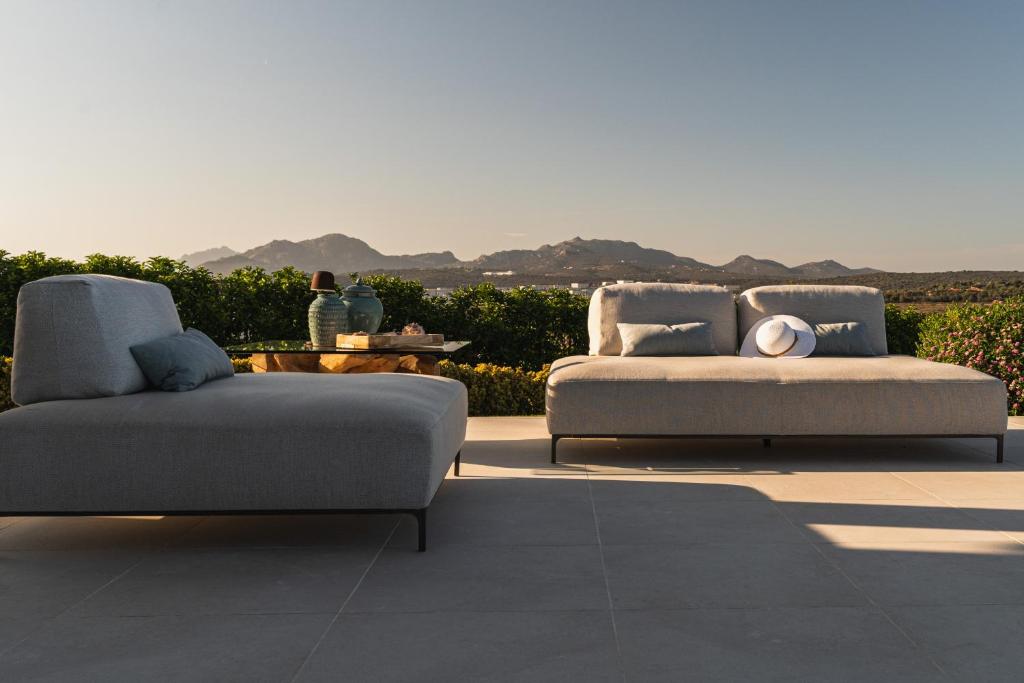 deux lits et un canapé assis sur un patio dans l'établissement Villa Blue Sphere with Pool by Wonderful Italy, à Olbia