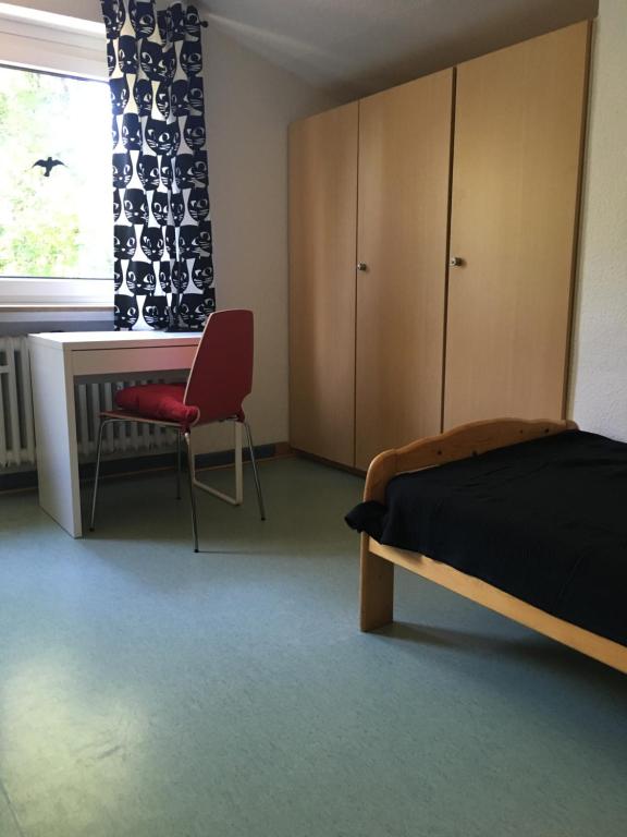 a bedroom with a bed and a desk and a chair at Schullandheim Kronenburg GmbH in Kronenburg