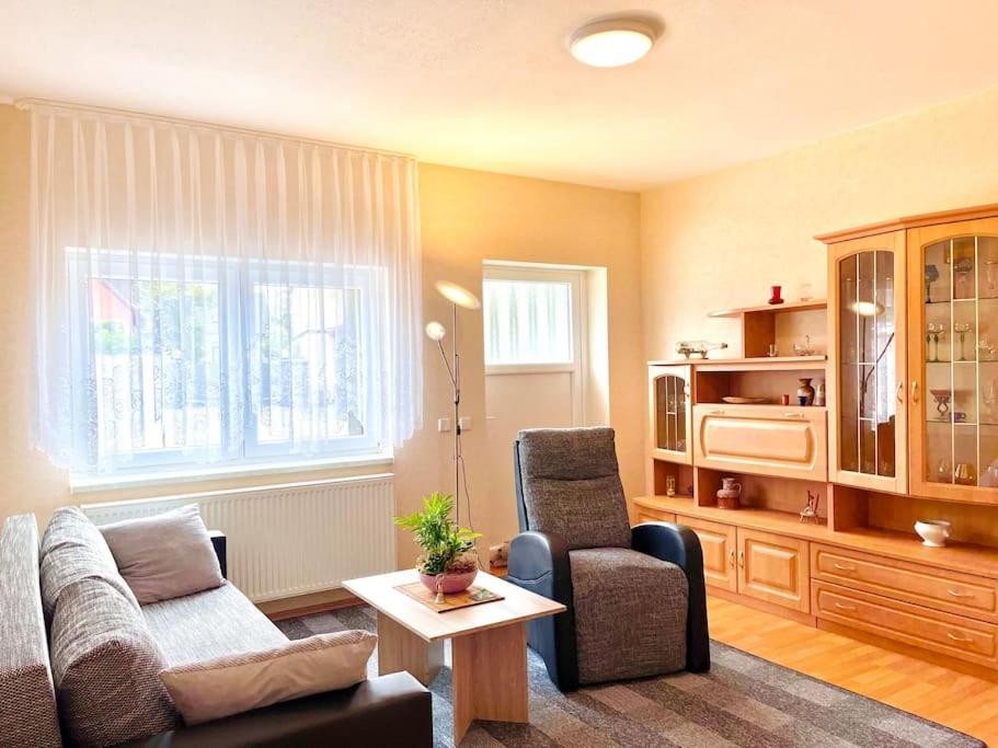 una sala de estar con un sofá y una silla en Turmhof Jüterbog, en Jüterbog