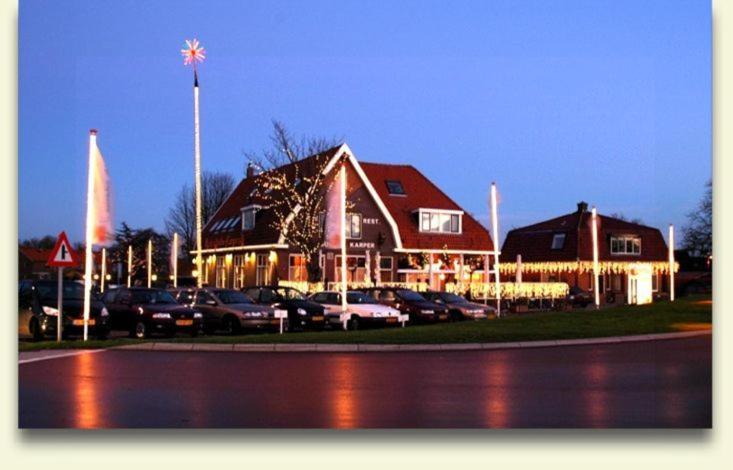 a large building with cars parked in a parking lot at De Gouden Karper in Rustenburg