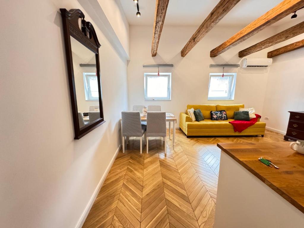 a living room with a table and a yellow couch at City buzz by Mili in Belgrade