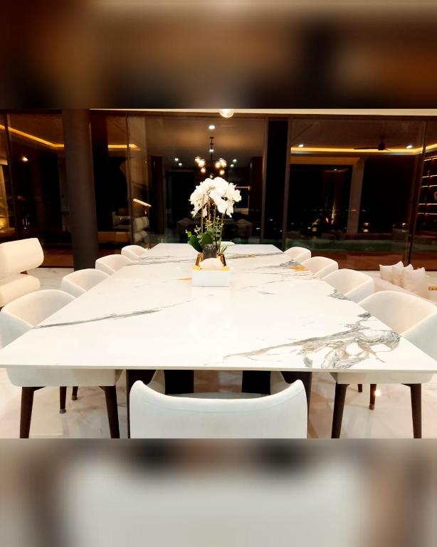 a white table with white chairs and a vase of flowers at House Of Sea Breeze in Uluwatu