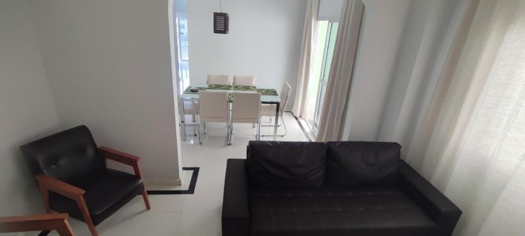a living room with a black couch and a chair at Apartamento encantador in Peroção