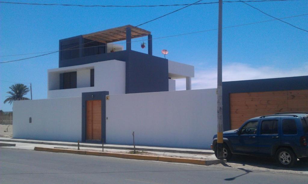 a blue van parked in front of a building at Los Libertadores Paracas Beach House in Paracas