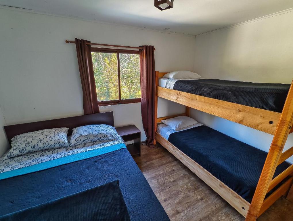 una camera con 2 letti a castello e una finestra di Habitación n°4 | Hostal La Casona Pucón a Pucón