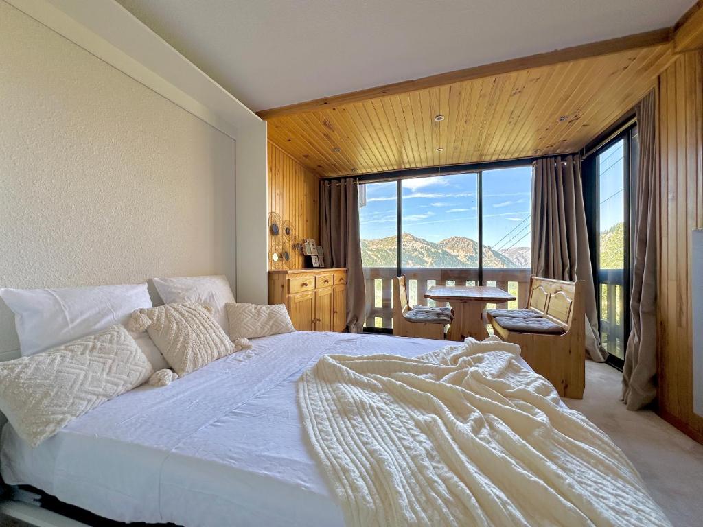 une chambre avec un grand lit et une grande fenêtre dans l'établissement 4 Seasons for 8 persons with Sauna and Local Ski, à Isola