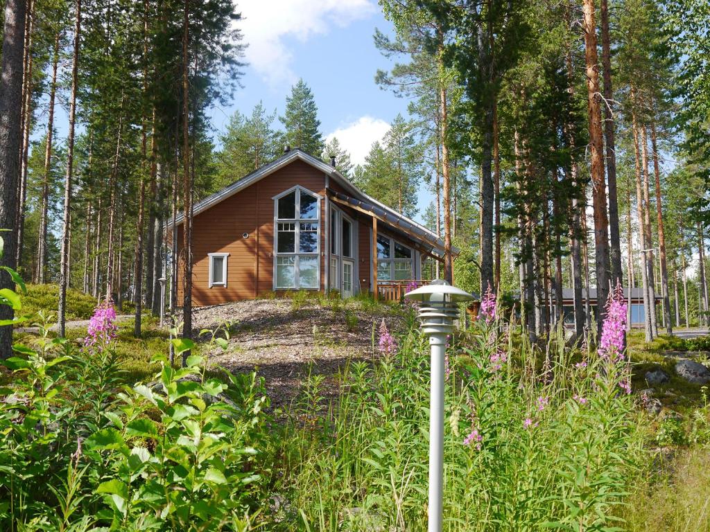 uma cabana de madeira na floresta com um jardim em KolinPilvi em Kolinkylä