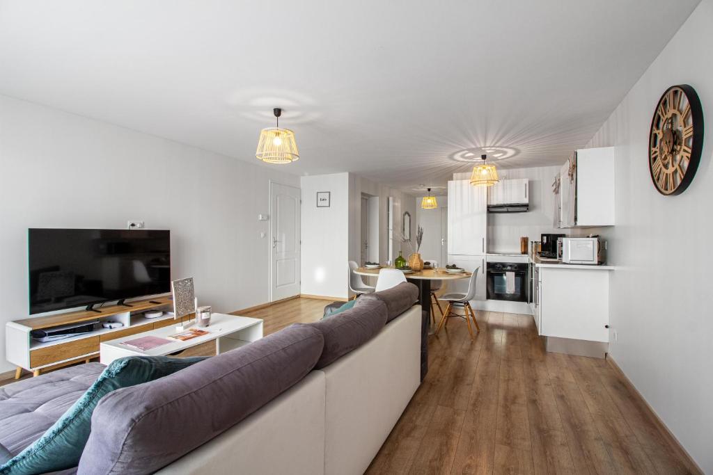 Il comprend un salon avec un grand canapé et une cuisine. dans l'établissement Sweet-Cozy, à Knutange