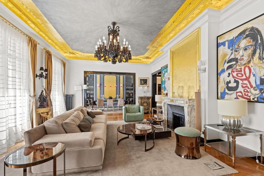 un salon avec un canapé et une cheminée dans l'établissement Spectacular 3BR Luxury Residence - Arc de Triomphe, 264m2, à Paris