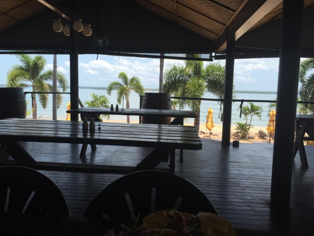 a dining room table with chairs and a patio at Crab Claw Island in Bynoe Harbour
