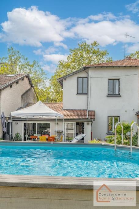 une piscine devant une maison dans l'établissement Maison à Lyon Parilly avec Piscine, Jardin, Parking Privé & Proche Eurexpo, à Vénissieux