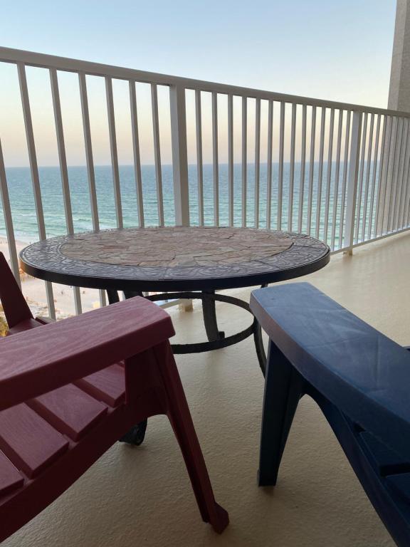 einen Tisch und eine Bank auf einem Balkon mit Meerblick in der Unterkunft Beach Front Condo in Panama City Beach in Panama City Beach
