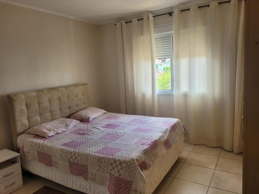 a bedroom with a bed and a window at apto para 2 pessoas in Santa Rosa