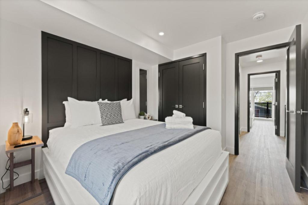 a bedroom with a large white bed with black cabinets at Luxury 171-7 Condos with Magnificent Lakeviews in Leamington