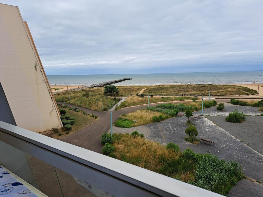 une vue sur la plage depuis le balcon d'un immeuble dans l'établissement Bel appart rénové 2 ch, face mer, garage, ascenseur - FR-1-323-548, à Saint-Jean-de-Monts