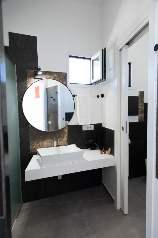 a bathroom with a white sink and a mirror at Le Cave di Fontane Bianche in Cassibile
