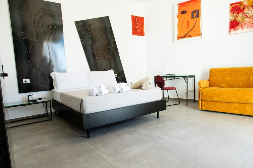 a bedroom with a bed and a chair and a couch at Le Cave di Fontane Bianche in Cassibile