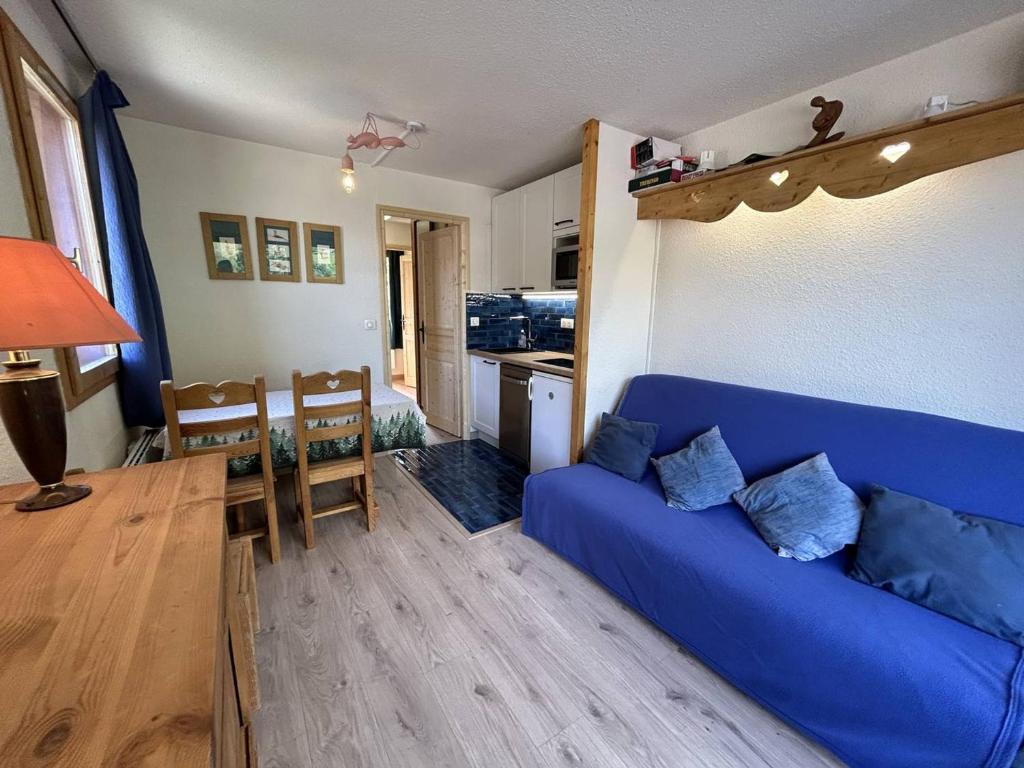 un salon avec un canapé bleu et une cuisine dans l'établissement Charmant 2 pièces à Méribel avec balcon et WIFI, pieds des pistes - FR-1-355-260, à Les Allues