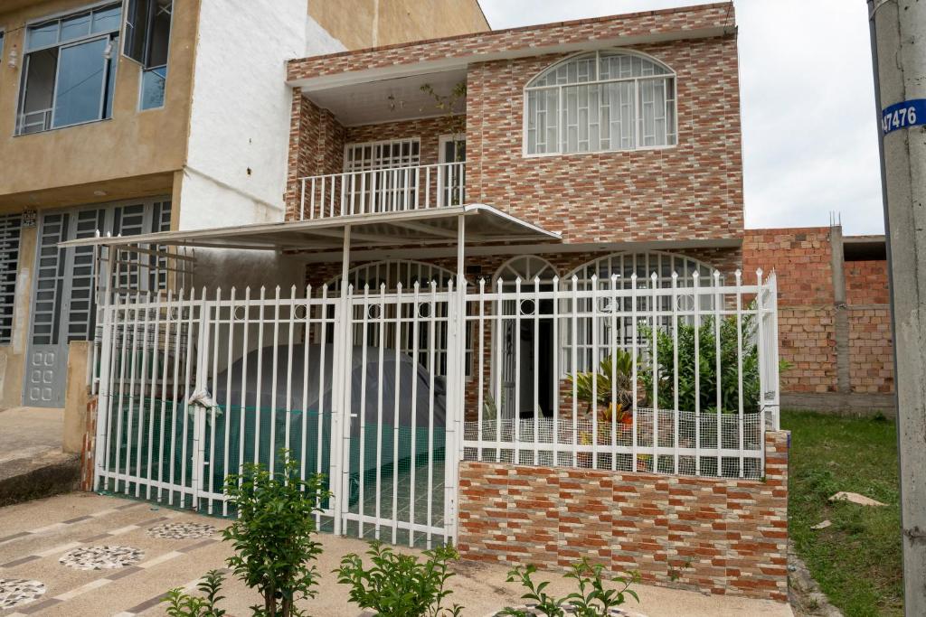 a white gate in front of a house at Lala's House Fusagasugá in Fusagasuga