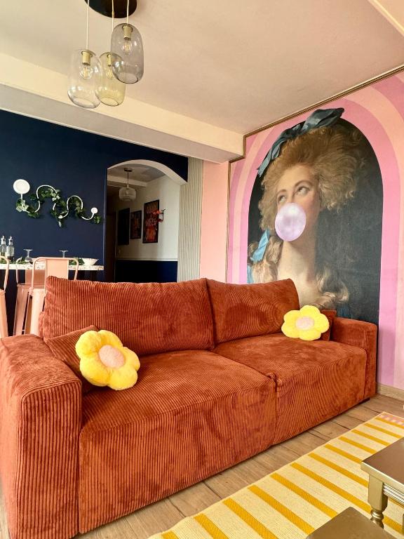 - un salon avec un canapé et une peinture d'une femme avec un masque dans l'établissement Appartement Pop Art, à Louviers