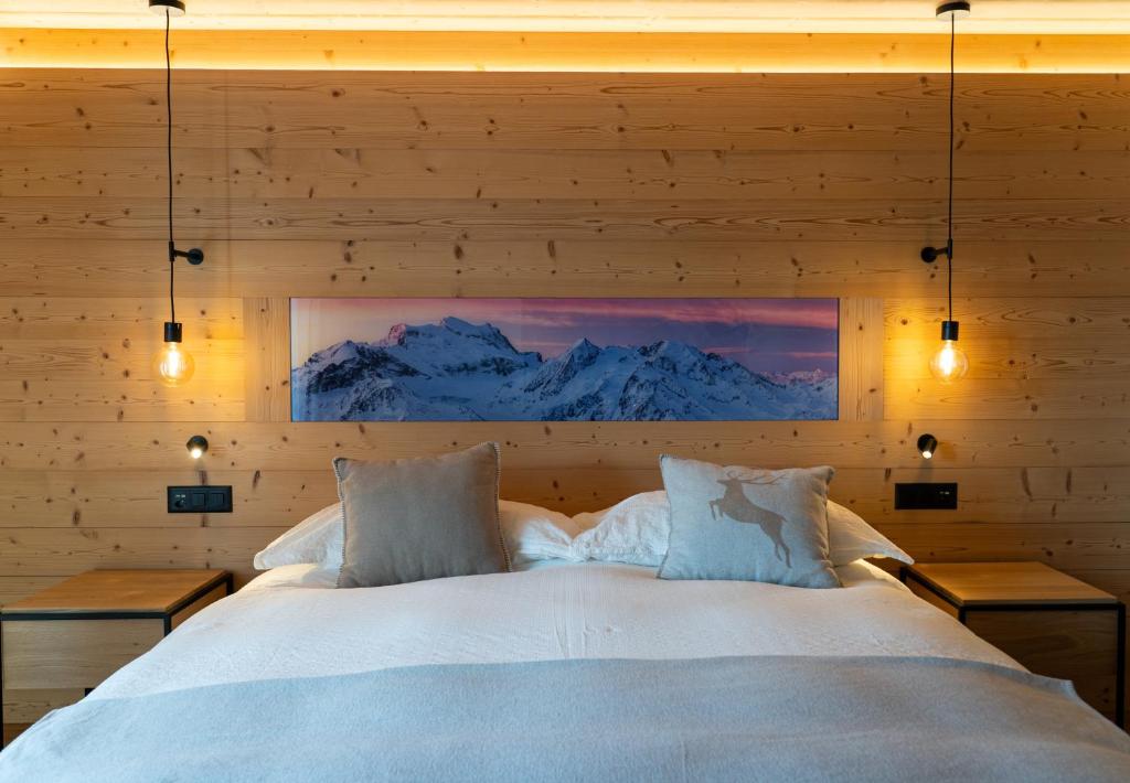 a bedroom with a large bed in a wooden wall at Hotel Les Chamois in Verbier