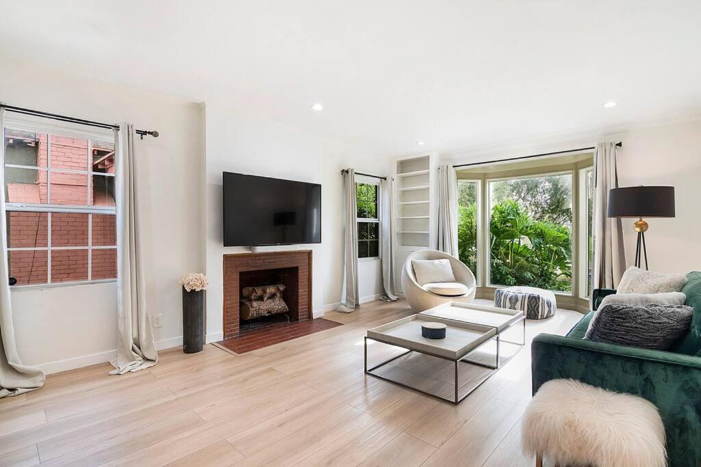 a living room with a green couch and a fireplace at Updated 3-Bedroom LA Home with Backyard, BBQ & Family-Friendly Amenities in Los Angeles